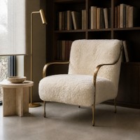 Fauteuil de salon sculptural avec accoudoirs en métal doré et pieds coniques pour salons et suites d'hôtel