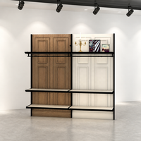 Porte-vêtements commercial en métal noir avec panneau arrière en bois bicolore blanc et étagères doubles suspendues