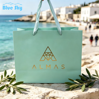 Sacs shopping en papier PPWR élégants et personnalisés OEM/ODM, couleur verte, avec logo en feuille d'or, sacs shopping en papier haut de gamme pour la vente au détail de vêtements