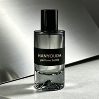 Flacon atomiseur de parfum cylindrique haut de gamme gris fumé à base épaisse, avec fond créatif en forme de montagne de glace et capuchon noir brillant, en verre personnalisé