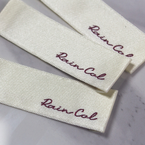 Étiquette tissée beige damassée haute densité avec logo personnalisé pour vêtements, étiquettes souples pliées sur le bord pour pulls - Product Image 3