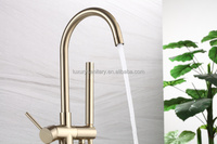 Baignoire autoportante en acrylique doré brossé avec robinetterie de douche intégrée pour salle de bain de villa
