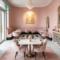 Ensemble de mobilier de restaurant et café : Sièges de banquette incurvés élégants à capitonnage vertical, chaise en velours rose, table ronde en pierre frittée