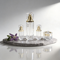 Flacons cylindriques de luxe en verre dépoli transparent mat, avec pompe pulvérisatrice pour lotion de soin, gravure et bouchon à accent doré sérigraphié