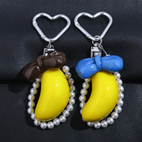 Vente en gros : Breloque de sac banane Kawaii tendance, porte-clés avec nœud et chaîne de perles et fermoir cœur, cadeau adorable pour filles