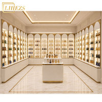 Vitrine de présentation murale de parfums en verre, design de boutique de luxe sur mesure, or blanc, pour la vente au détail