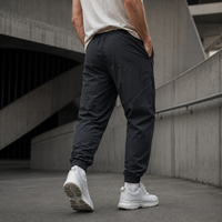 Pantalon de jogging pour homme OEM en nylon avec cordon de serrage à la taille, poche cargo zippée, revers élastiques, coutures courbées, style streetwear décontracté