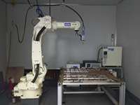 Robot de soudage OTC FD-V25 à 6 axes avec une charge utile de 25 kg et une portée de 1,71 m, équipé d'un positionneur de soudeur sur chenilles