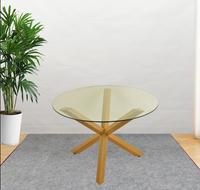 Table à manger ronde moderne avec plateau en verre noir et trois pieds en métal chromé croisés pour la maison ou l'hôtel, style farmhouse