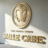 Plaque de signalisation personnalisée en métal 3D doré brossé avec logo dentaire en relief pour clinique dentaire de luxe, idéale pour l'identification de la marque à la réception.