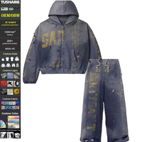 Survêtement imprimé streetwear avec sweat à capuche zippé délavé et déchiré, coupe personnalisée, et pantalon baggy orné de strass