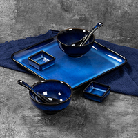 Services de table en céramique bleu cobalt, comprenant des bols, des assiettes, des plats et des cuillères