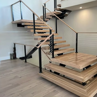 Escalier en bois à poutre centrale unique avec garde-corps en câble d'acier carbone noir et marches en bois massif pour villa intérieure