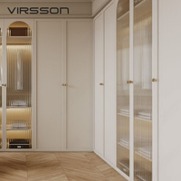 Système de dressing de luxe en L avec portes arquées en verre cannelé, poignées dorées et sol en chevrons – Conception personnalisée