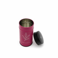 Boîte à thé ronde en métal rose personnalisée avec couvercle noir uni et motif floral blanc pour l'emballage de thé en vrac de qualité supérieure