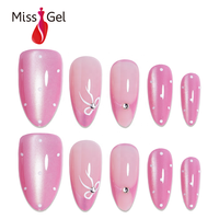 Ongles artificiels réutilisables 32 pièces rose bonbon effet œil de chat magnétique, forme amande moyenne, avec nœud blanc et strass à pois
