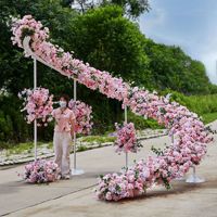 Dekorasi Latar Panggung Pernikahan Mewah Elegan, Gapura Spiral dengan Rangkaian Bunga Pink, Bunga Sutra