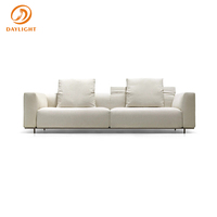 Canapé modulaire en tissu en forme de L, design minimaliste et épuré, avec base métallique basse et dossier en coussin moelleux, pour salon de luxe
