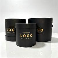 Boîte à chapeau ronde en forme de fleur avec couvercle, boîte cadeau cylindrique en papier noir mat avec logo en feuille d'or et poignée en ruban, taille et couleur personnalisées