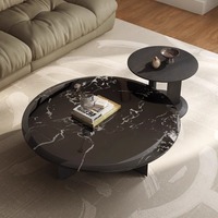 Table basse ronde en marbre noir de luxe, profil bas, pieds en métal noir en forme d'arc, sur mesure pour salon