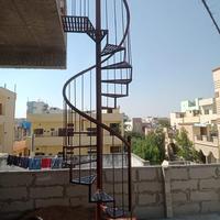 Escalier en colimaçon extérieur pour accès à entrepôt avec structure en acier de gros calibre et main courante circulaire sécurisée