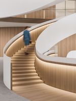 Escalier en métal courbé moderne de haute qualité avec rampe en verre pour usage intérieur dans un appartement ou une bibliothèque