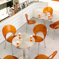 Moderne Kaffeehaus-Tische und -Stühle, ein Runder Edelstahltisch und Transparente Acrylstühle