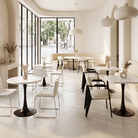Tables blanches de style minimaliste et chaises rembourrées douces, mobilier commercial pour pâtisserie et café