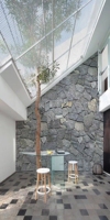 Revêtement mural en pierre naturelle moderne, irrégulière et brutalement taillée, gris, pour décoration extérieure de villa