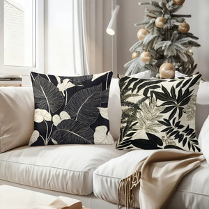 Élégantes coussinets décoratifs botaniques noirs et blancs pour une ambiance chaleureuse dans le salon, avec des chaussettes de Noël festives et des décorations en forme de bois de cerf. - Product Image 4