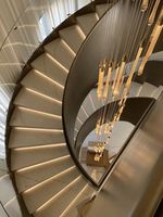 Escalier courbé en marbre et bois massif avec balustrade en fer forgé ornée, sur mesure pour villa européenne de luxe