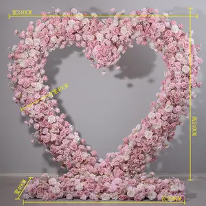 โค้งดอกไม้รูปหัวใจสีชมพูพร้อมขาตั้งดอกกุหลาบประดิษฐ์ฉากหลังงานแต่งงานตกแต่งเวทีหัวใจดอกไม้โค้ง