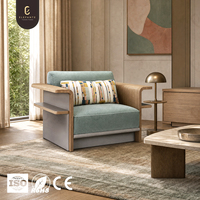 Fauteuil lounge moderne en bois de chêne avec panneau en cuir A2, revêtement en tissu F2, accoudoirs incurvés et étagère latérale pour les intérieurs de villas