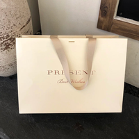 Sac en papier personnalisé pour marque de vêtements, sac en papier cartonné blanc 250g, logo imprimé or rose, design avec ruban suspendu