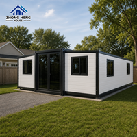 Maison modulaire moderne à double aile avec entrée centrale en verre, plusieurs fenêtres pour l'arrière-cour, logement familial, maison conteneur