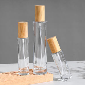 ผู้ผลิตขายส่งขวดน้ำหอมแก้วใสทรงกระบอกขนาด 30 มล. 50 มล. 100 มล. แบบหนา พร้อมฝาไม้ - Product Image 1