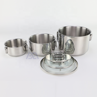 Set Peralatan Masak AXA Memiliki Desain yang Stylish dan Dapat Ditumpuk dalam Bahan Stainless Steel dengan Tiga Panci dalam Berbagai Ukuran dan Tutup yang Serasi dari Kaca