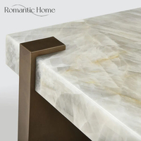 Table basse élégante et minimaliste de luxe en marbre naturel avec base arquée en bronze pour hôtel de luxe, hall d'entrée ou salon.