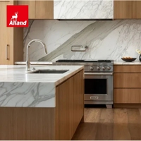 Cuisine moderne en placage de chêne blanc, définie par des veines de marbre spectaculaires, avec une île sculpturale en demi-cascade et une armoire de rangement en panneaux de marbre.