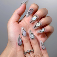 Faux ongles en acrylique faits main, base blanc crème, bordure métallique effet lave, incrustation nacre irisée, forme amande, longueur moyenne, personnalisables