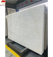Dalle naturelle rétro-éclairée par LED de conception moderne de marbre d'onyx blanc de fissure de glace translucide pour le mur de fond de villa prix par mètre carré