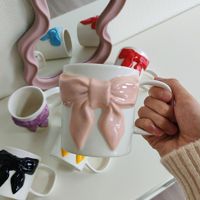 Tasse à café en céramique de style américain élégante avec un design en forme de nœud, dotée d'un motif sous-glaçure peint à la main inspiré d'Instagram