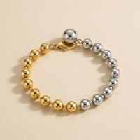 Bracelet minimaliste en acier inoxydable avec perles, orné d'un mélange de sphères polies or et argent et d'un fermoir mousqueton