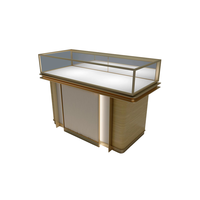 Comptoir de présentation de bijoux en verre LED doré champagne à panneaux rainurés verticaux, base en bois clair, vitrine de boutique