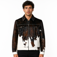 Veste en cuir de vachette noir, marron et blanc avec poils, fermeture éclair, poches à rabat sur la poitrine, surpiqûres contrastées, style rétro streetwear pour homme