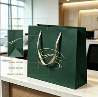 Sac shopping en papier vert foncé de luxe personnalisé avec motif doré et poignée en ruban pour les marques commerciales et l'emballage de détail haut de gamme