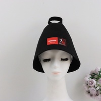 Un gorro de sauna negro de pura lana que hereda el legado en su frente mientras el calor rinde homenaje a los setenta y cinco años de maestría.
