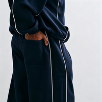 Ensemble de survêtement streetwear pour homme personnalisé, comprenant un sweat à capuche épais bleu marine et un pantalon de jogging, avec passepoil contrastant et coupe oversize