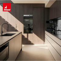 Armoires de cuisine Alland bicolores sans poignées en laque blanche et placage de noyer avec îlot central incurvé à façade cannelée pour constructeur de villas