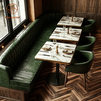 Ensemble de mobilier moderne pour café-restaurant : Table et chaises en pierre frittée verte, banquette en cuir vert en forme de L, et canapé banquette.